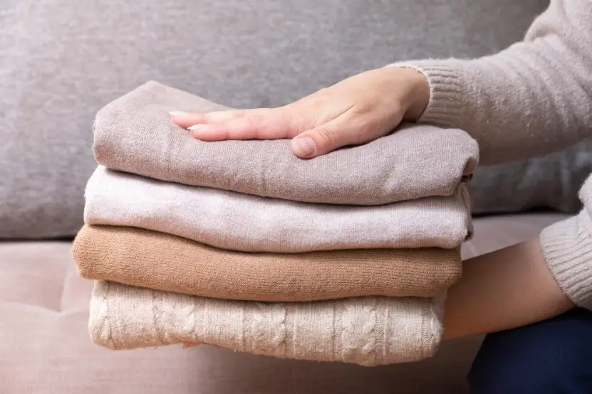 Folded wool garments stacked neatly to represent proper wool care