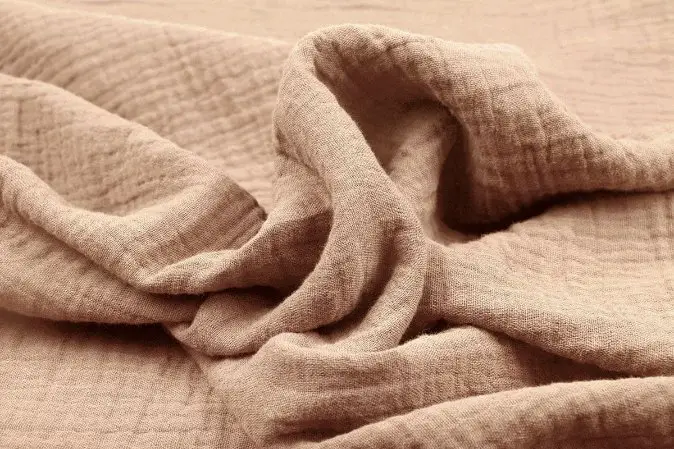 Close up of wool gauze fabric showing soft texture and open weave