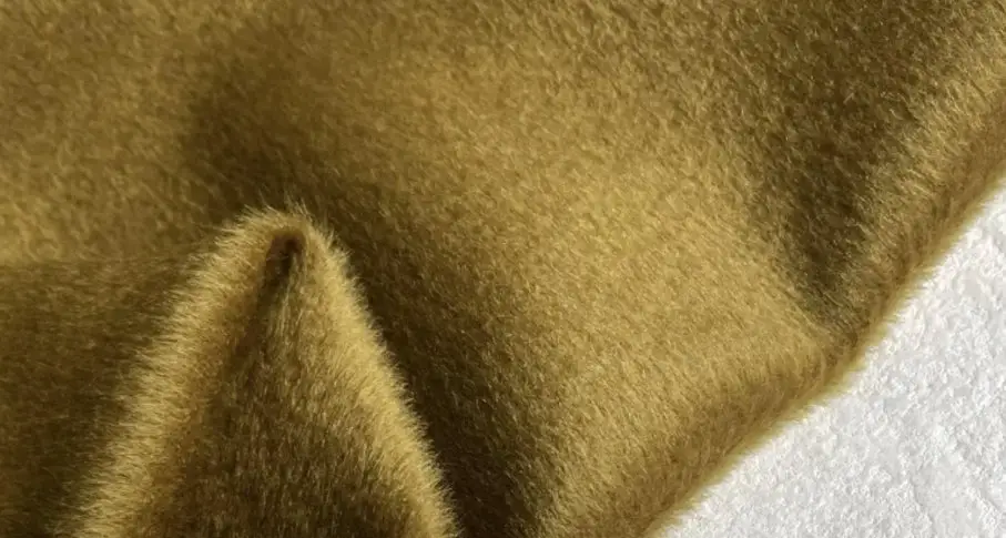 Close up of natural alpaca wool fabric showing fine fibers and warm earthy tones