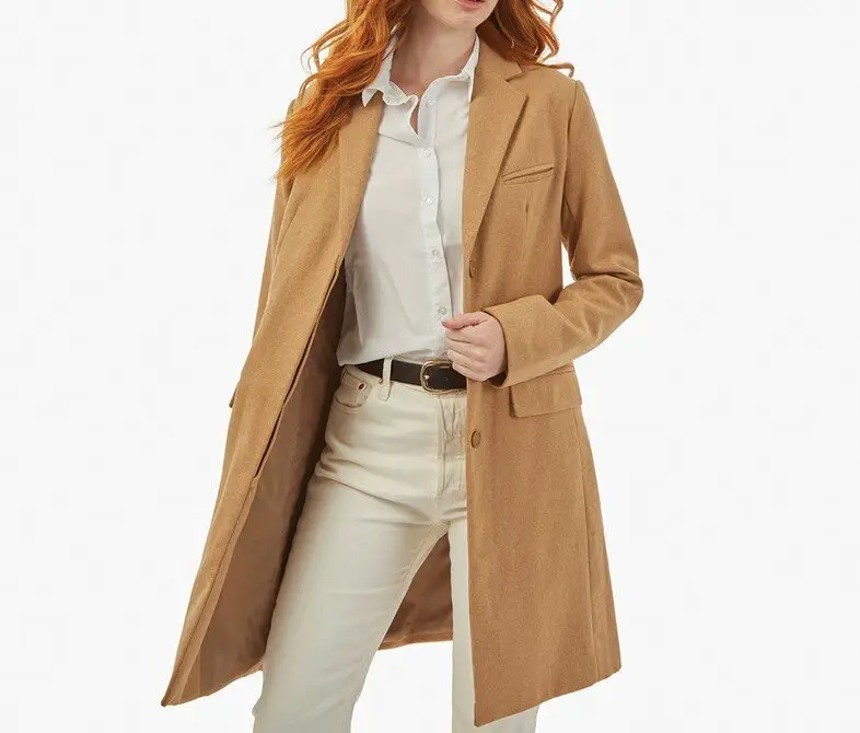 Woman wearing a camel wool coat styled with neutral clothing
