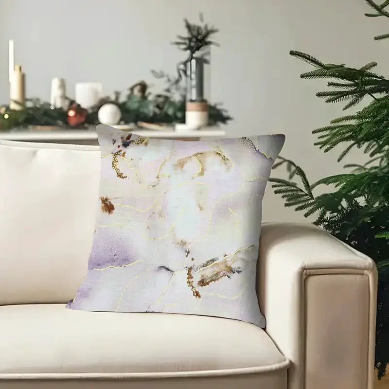 Decorative pillow with a pastel abstract design placed on a cream colored sofa
