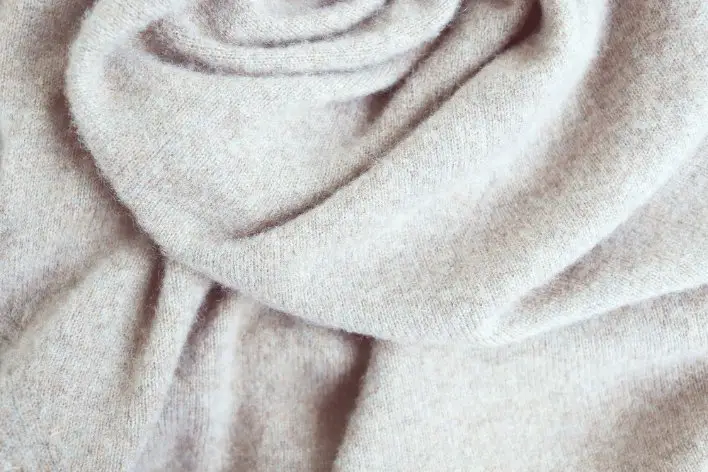 Close up of cashmere wool fabric showing fine texture and soft drape
