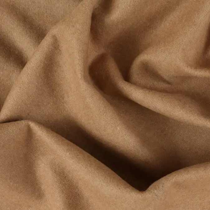 Close up of camel wool fabric showing soft texture and natural warm brown color