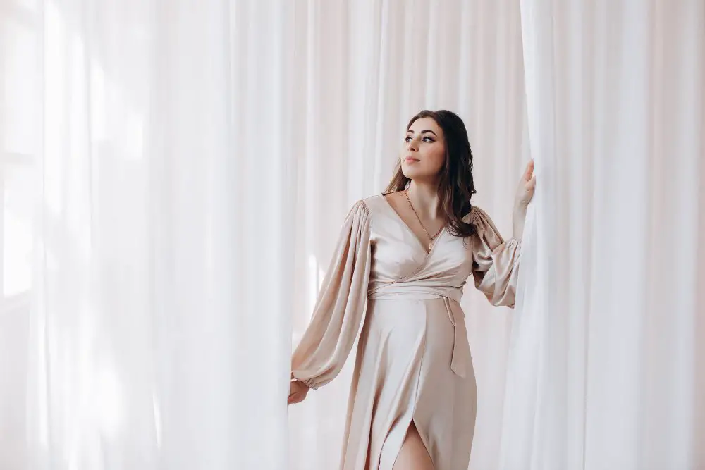 Woman wearing a flowing satin blend dress with soft drape and elegant sheen