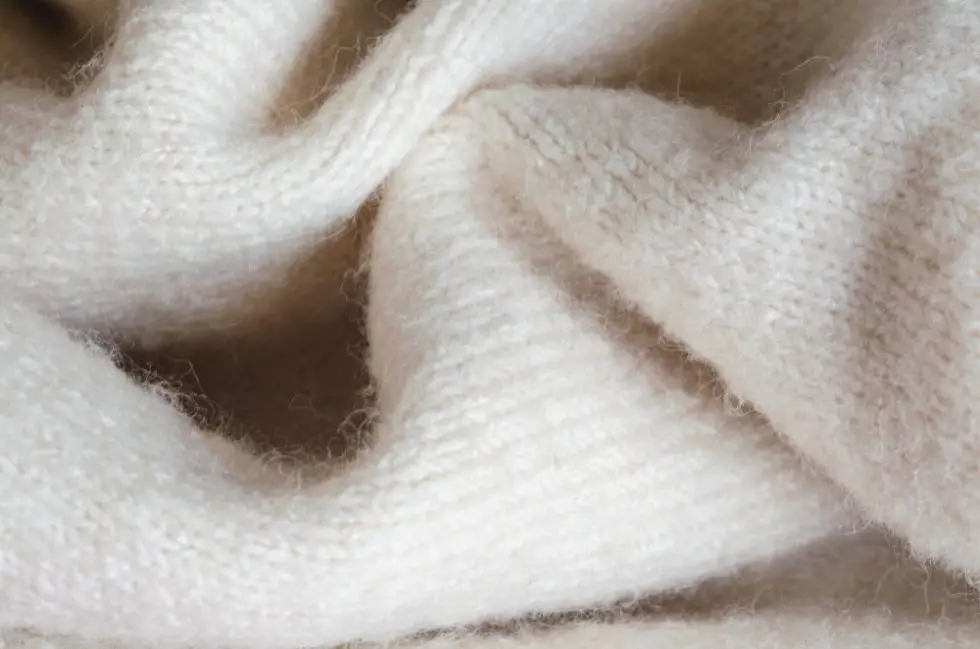 Soft white wool fabric with visible fibers and gentle folds