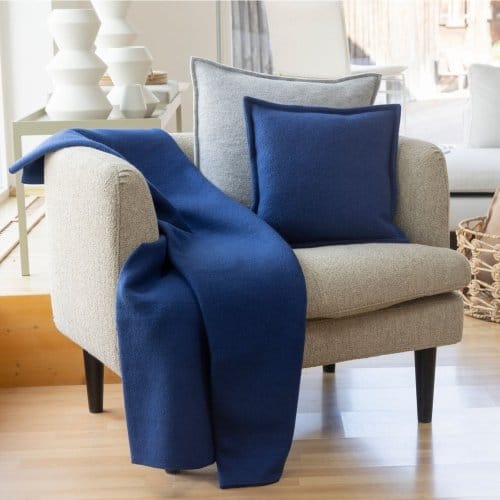 Boiled wool throw blanket draped over a chair showing warmth, softness, and home decor use