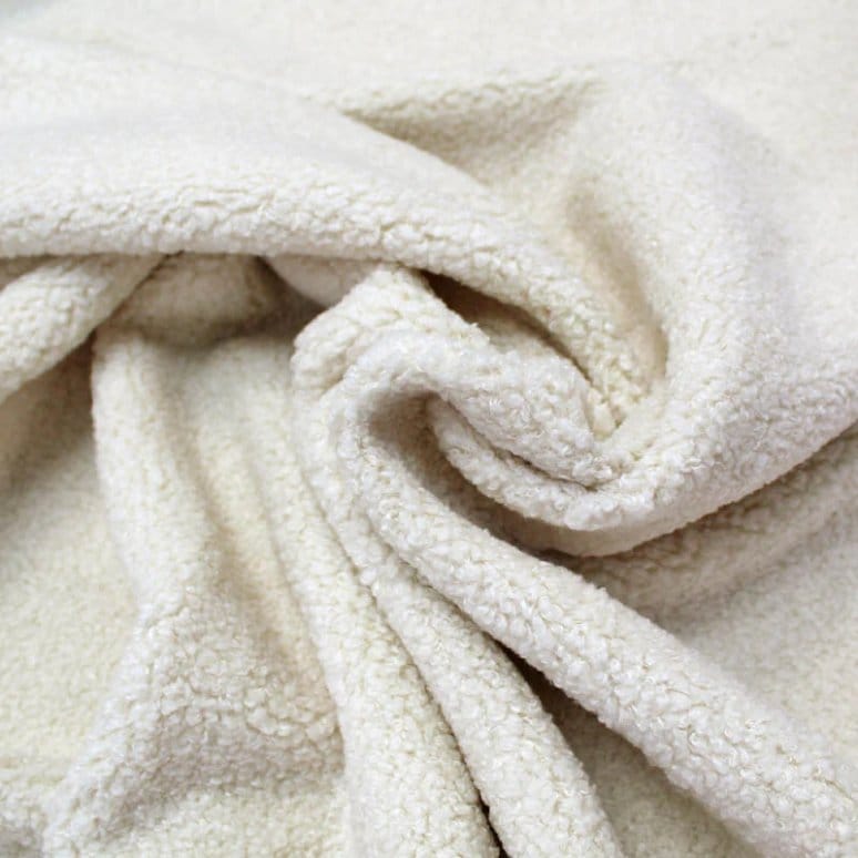 Close up of boucle fabric showing looped yarn texture and soft, cozy appearance