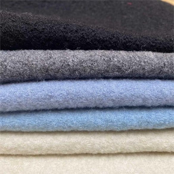 Stacked boiled wool fabrics showing thickness and texture for proper care and maintenance guidance