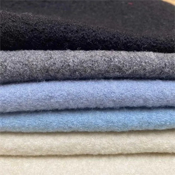 Stacked boiled wool fabrics showing thickness and texture for proper care and maintenance guidance