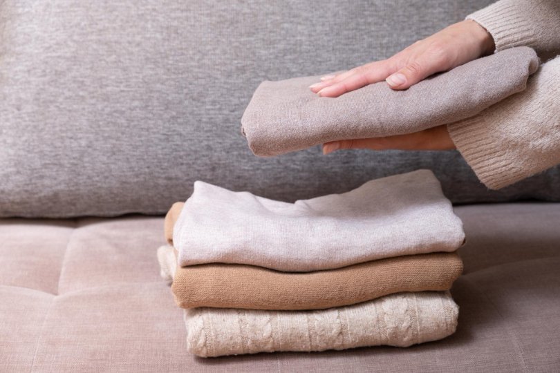 Folded wool garments demonstrating proper care and maintenance of wool Voltaire fabric