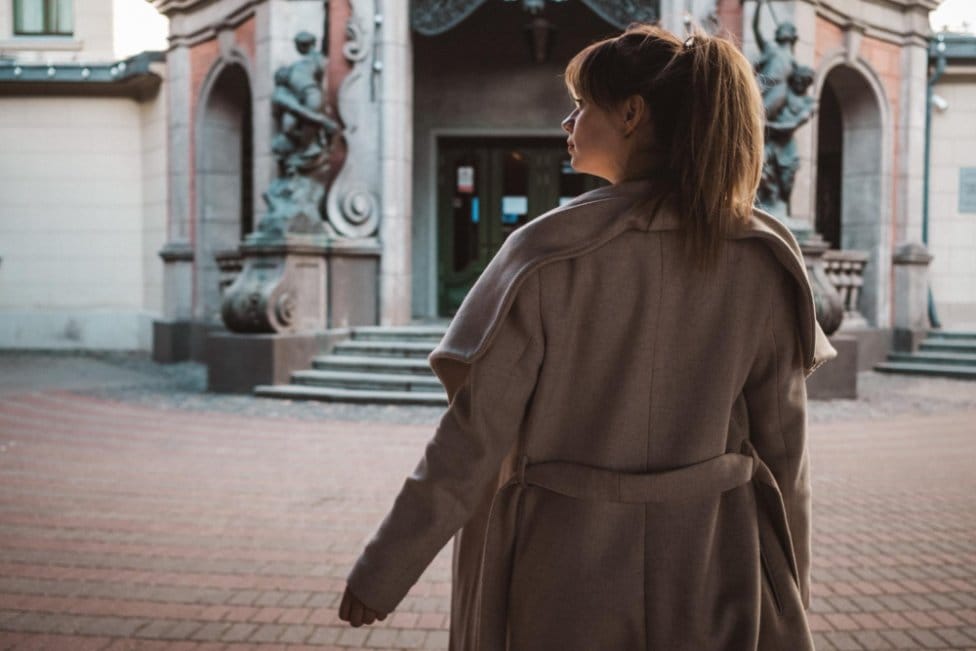 Woman wearing a classic wool coat in an architectural outdoor setting