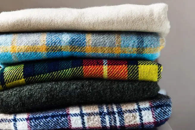 Stacked wool flannel fabrics representing proper care and maintenance techniques