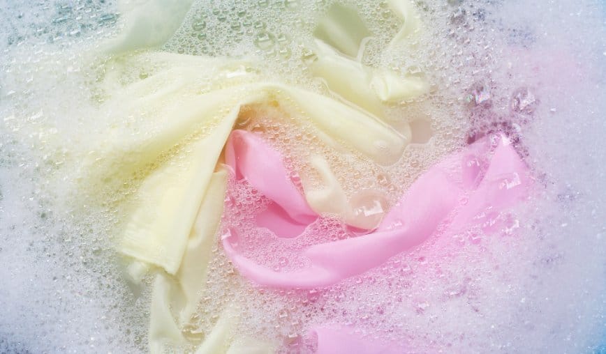 Hand washing chiffon fabric gently in soapy water to prevent damage and color bleeding