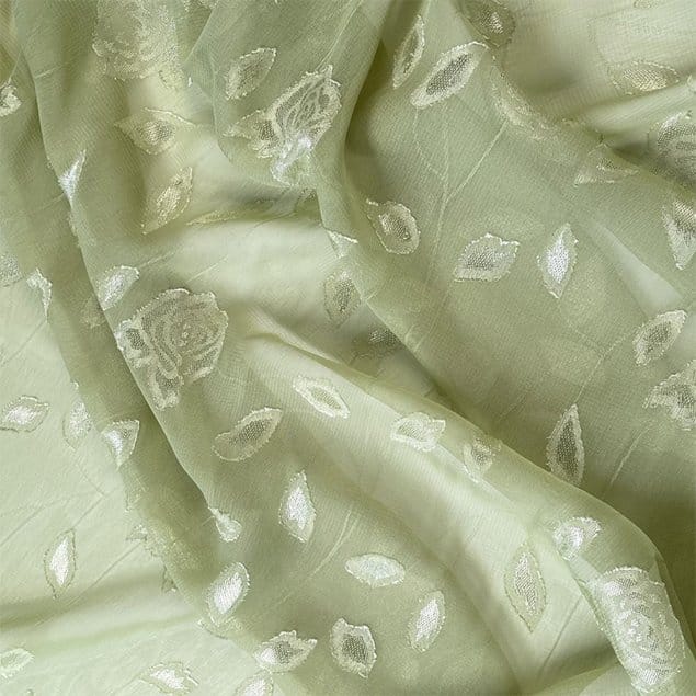 Close up of jacquard chiffon fabric showing woven floral motifs and sheer texture