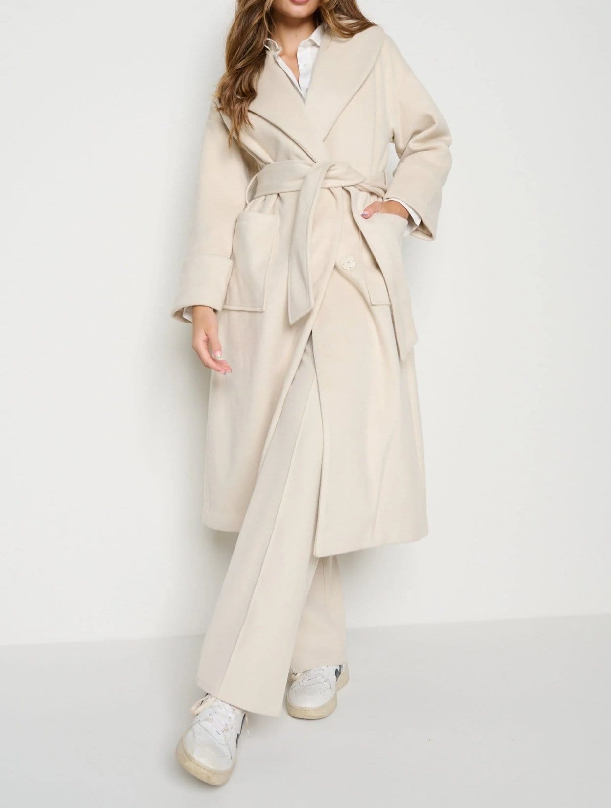 Woman wearing a modern wrap coat made from soft wool fabric