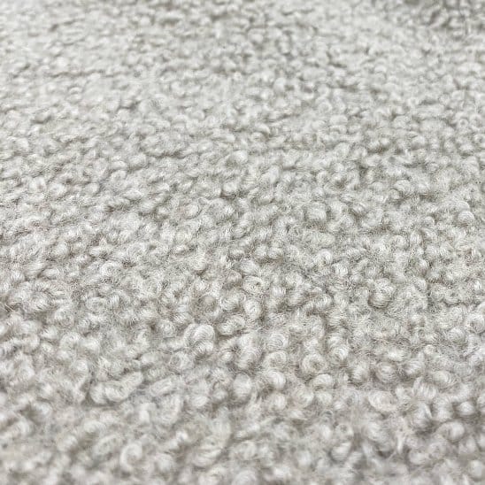 Pure wool bouclé fabric texture showing natural loops and consistent wool fibers