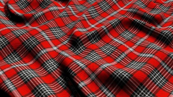 Traditional red tartan fabric with classic Scottish plaid pattern and deep woven texture