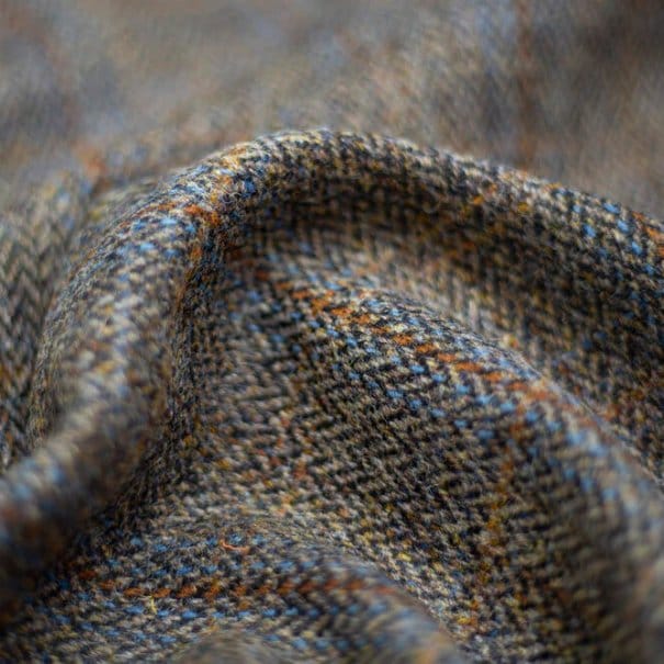 Close up of tweed fabric showing textured weave and multicolored yarns