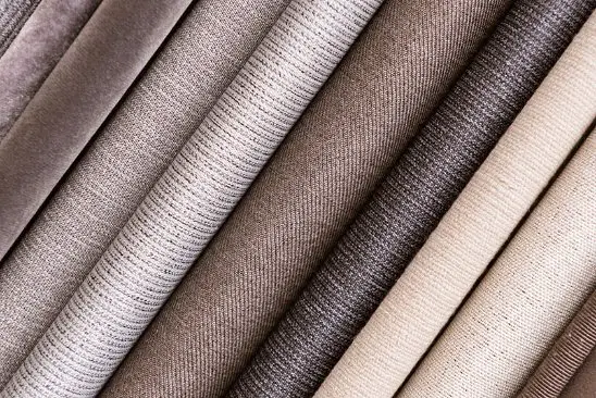 Folded fabric samples showing texture and weave details useful when buying delaine fabric