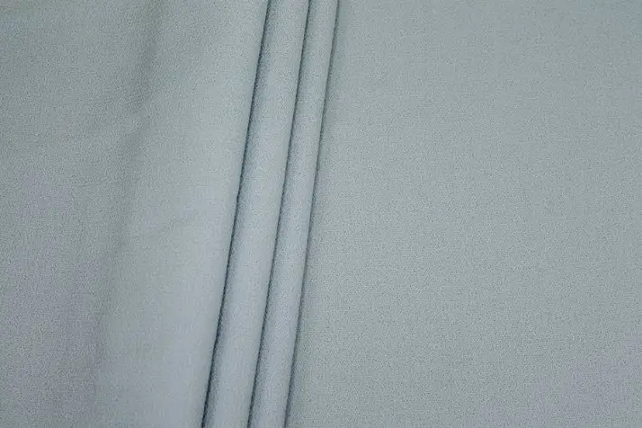 Close up of wool crepe fabric showing pebbled texture and soft structured drape