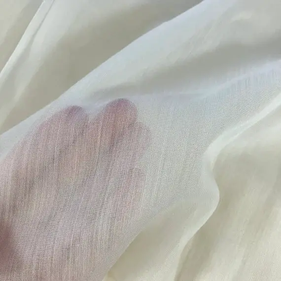 Close up of wool voile fabric showing sheer texture and lightweight weave