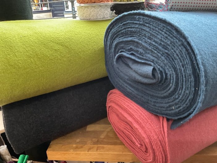 Rolled boiled wool fabrics in multiple colors displayed for selecting quality boiled wool material