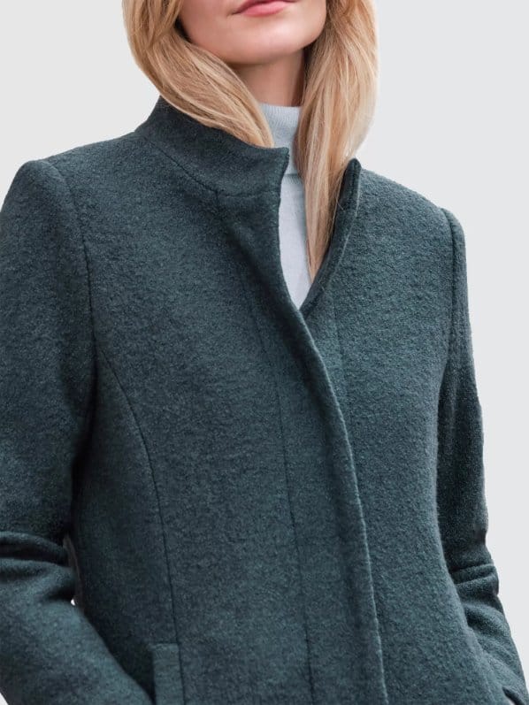Woman wearing a bouclé wool coat showing textured fabric, warmth, and tailored outerwear style