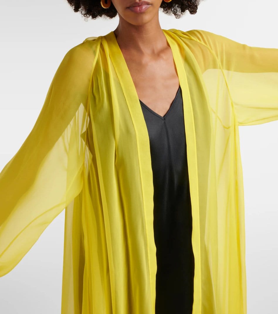Woman wearing sheer yellow chiffon duster layered over a black outfit