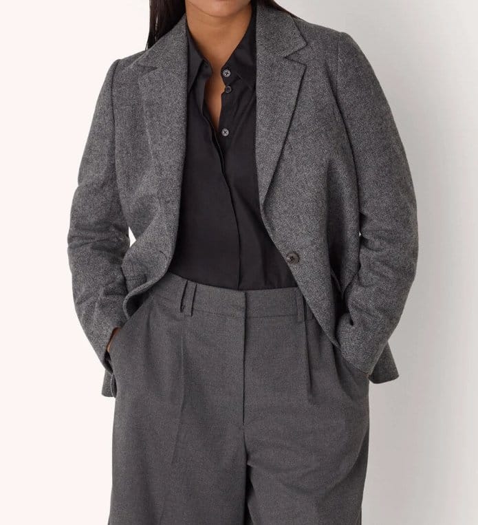 Grey herringbone wool blazer worn as part of a tailored outfit