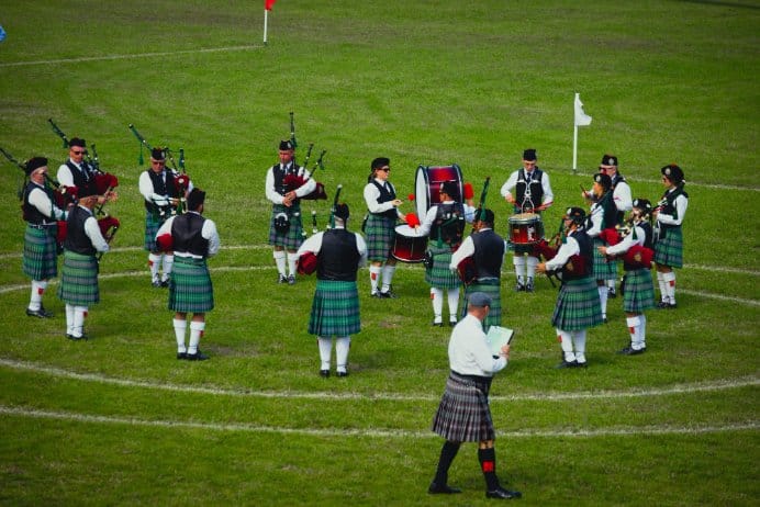 Group of people wearing traditional tartan wool kilts at outdoor event