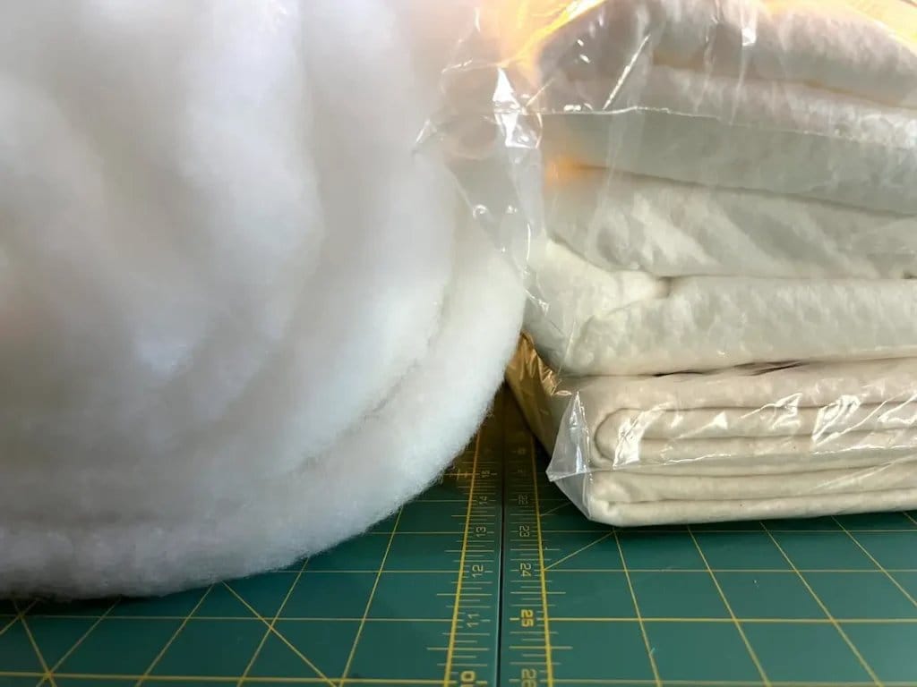 Rolled and packaged wool batting showing different thickness options for quilting and insulation