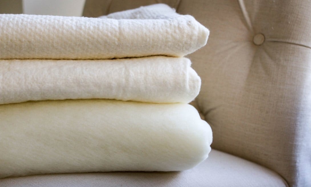 Stacked wool batting layers showing thickness and structure before washing