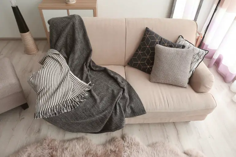 Wool flannel throw blanket draped over a sofa in a cozy interior