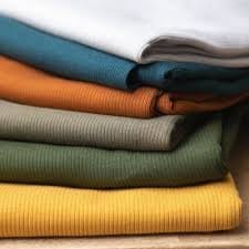 Folded wool jersey fabrics in different colors representing fabric buying guide
