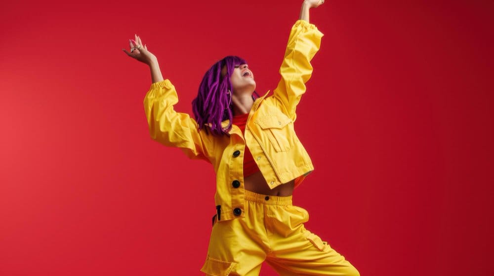 Bold canary yellow coordinated outfit with cropped jacket and pants styled against red background