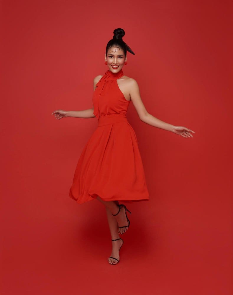 Candy Apple Red sleeveless midi dress styled against red backdrop for bold monochrome look