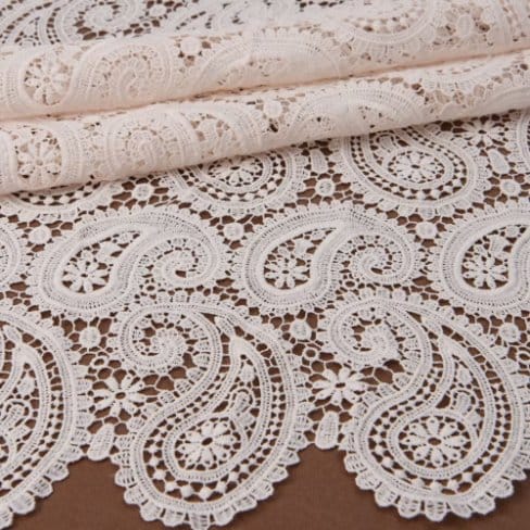 Chemical lace fabric with intricate floral and paisley patterns, lightweight and semi sheer textile used in fashion and dressmaking