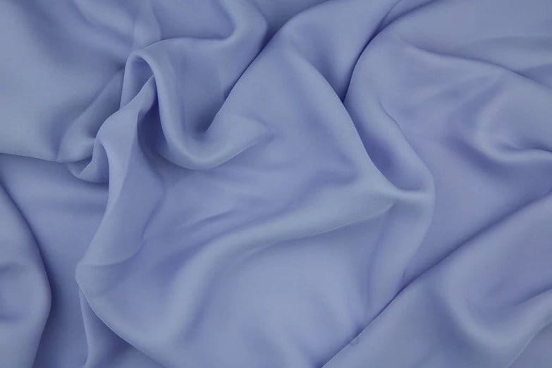 Soft blue double face chiffon fabric draped in natural folds showing smooth texture, lightweight feel, and elegant flowing structure