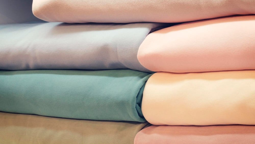 Close up of pastel stretch chiffon bolts stacked to show smooth texture