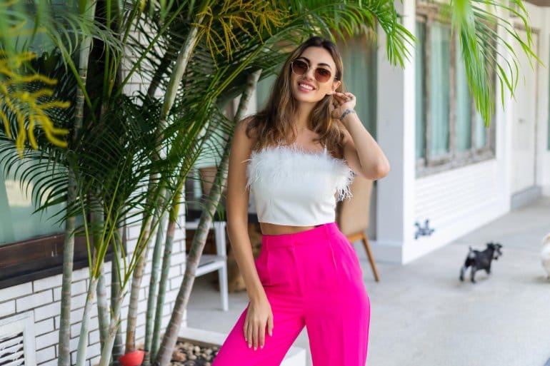 Magenta wide leg trousers styled with white feather top for bold summer outfit inspiration