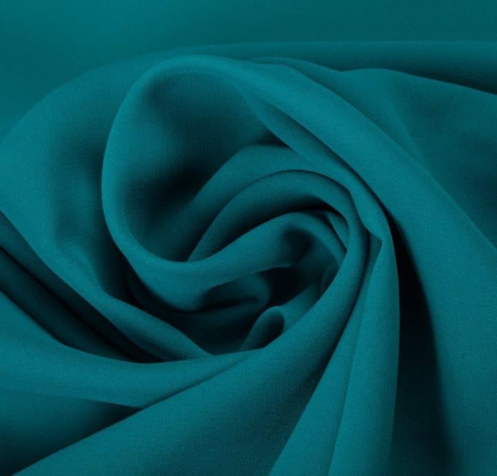 Close up of teal polyester georgette chiffon showing soft crepe texture