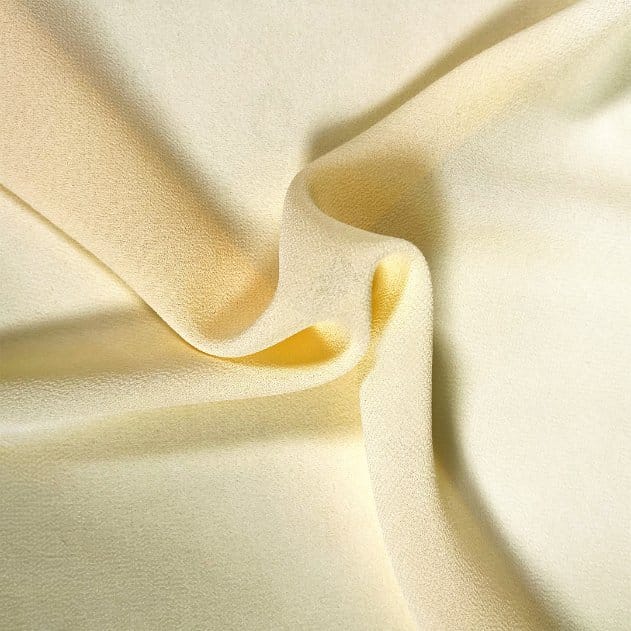 Close up of soft yellow polyester pearl chiffon fabric with smooth folds and lightweight wrinkle resistant texture