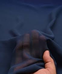 Hand testing navy georgette chiffon to check transparency and texture