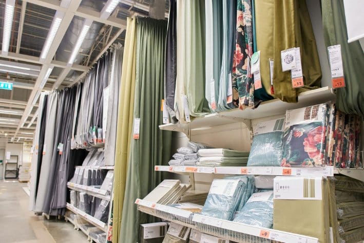 Fabric store aisle displaying bolts of chiffon and curtain materials