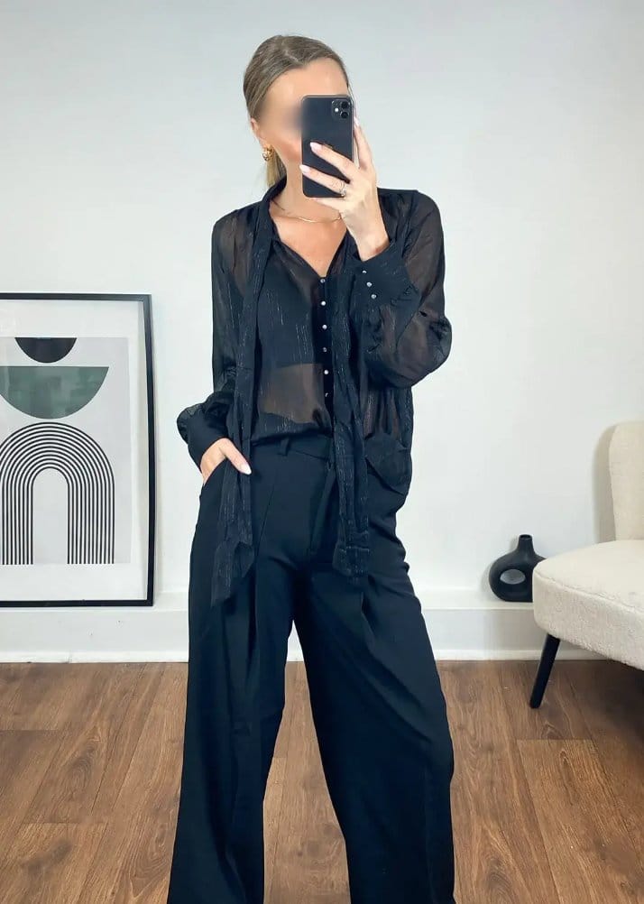 Black lurex chiffon blouse with sheer texture and subtle sparkle styled for evening wear