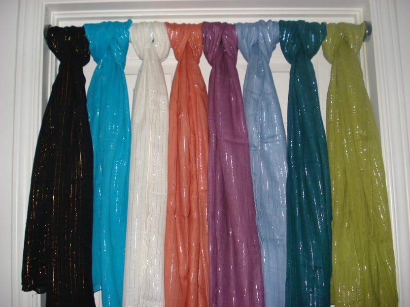 Colorful lurex chiffon scarves hanging together showing lightweight shimmer and sheer texture
