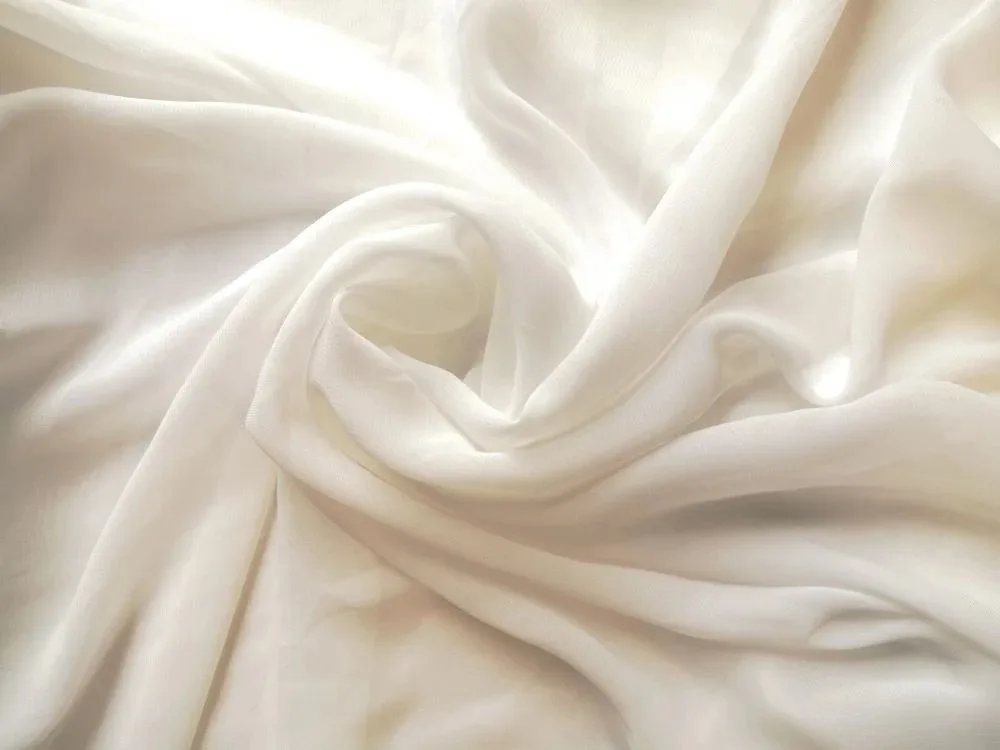 White polyester chiffon fabric close up showing sheer weave lightweight structure and soft flowing drape