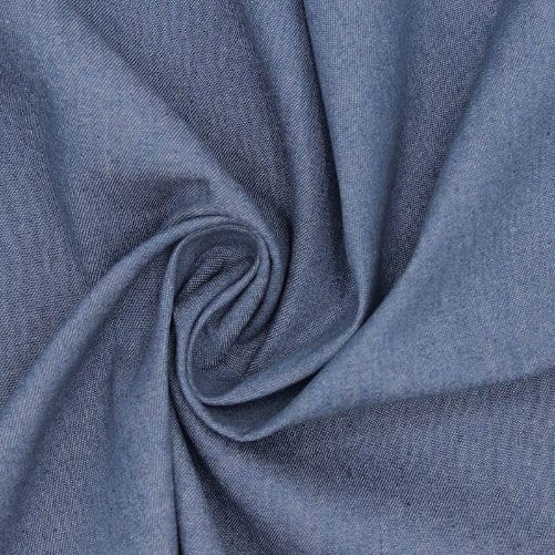 Close-up of 100% cotton denim fabric in soft blue folds showing natural texture and woven surface detail.