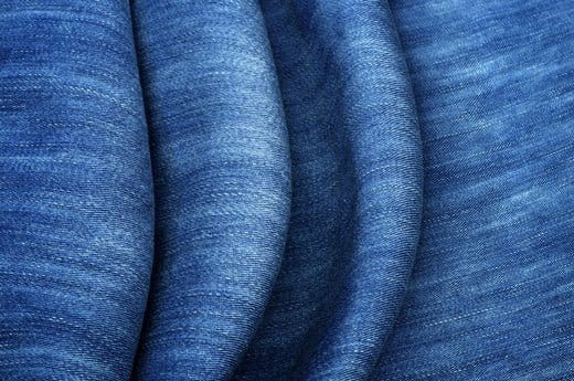 Close up of stretchy denim jeans fabric showing elasticity used in stretchable jeans also known as jeggings or elastane denim