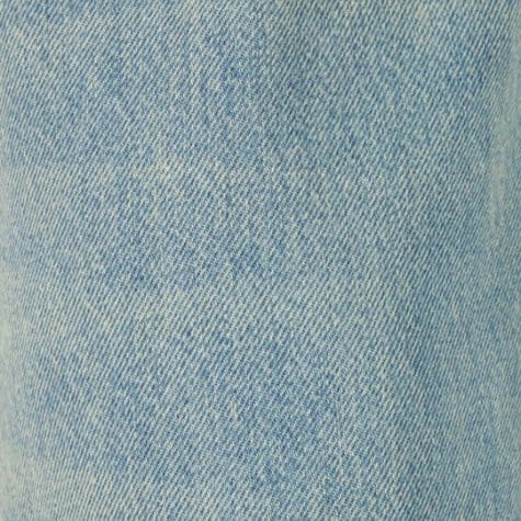 Light blue sand washed denim fabric with a soft faded twill texture and worn-in surface.